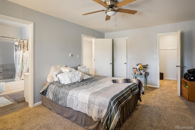 carpeted bedroom with ensuite bathroom and ceiling fan