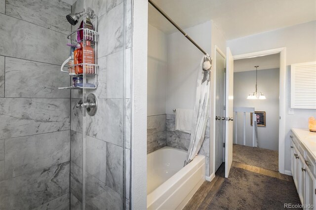 bathroom with shower / bath combination with curtain, hardwood / wood-style flooring, and vanity