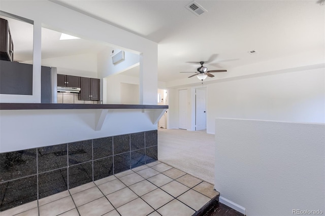 3570 Center Ave, Denver, CO 80219 - kitchen with under cabinet range hood, dark countertops, a ceiling fan, light colored carpet, and dark brown cabinets