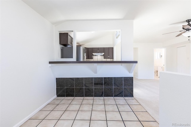 3570 Center Ave, Denver, CO 80219 - kitchen featuring a ceiling fan, under cabinet range hood, vaulted ceiling, dark countertops, and freestanding refrigerator