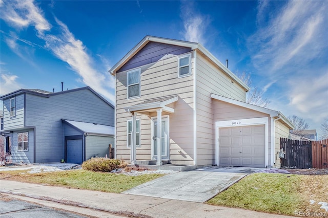 traditional home with concrete driveway, an attached garage, and fence