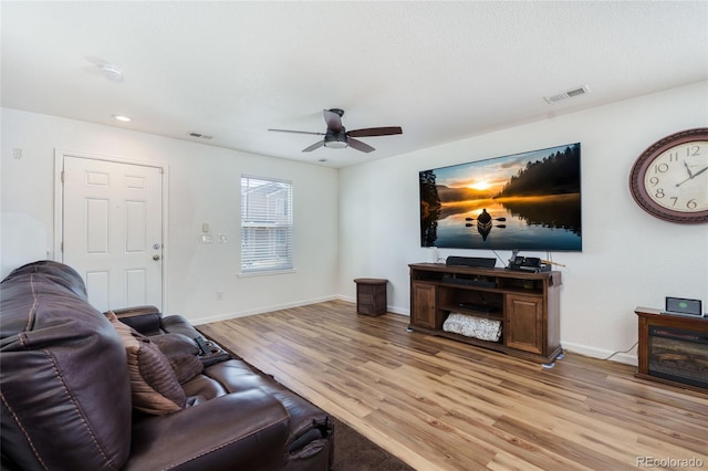 living area with baseboards, visible vents, and light wood finished floors