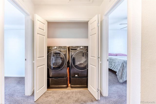 laundry room featuring laundry area, light carpet, and washer and clothes dryer