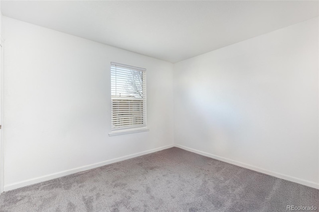 empty room with baseboards and light colored carpet