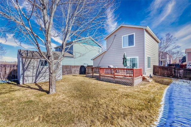 back of house with an outbuilding, a yard, a deck, and a fenced backyard