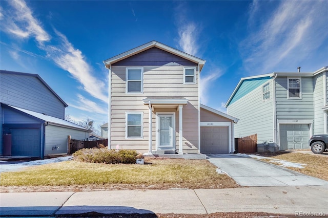 traditional home featuring driveway, an attached garage, fence, and a front lawn