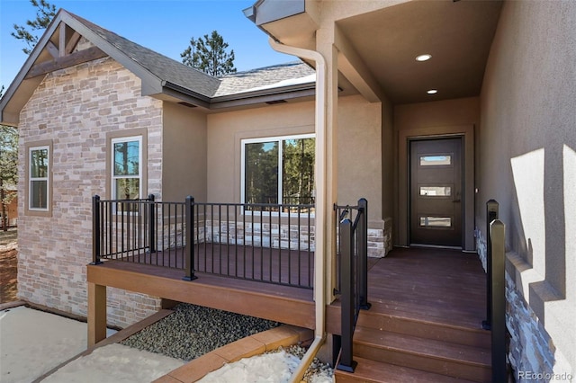 doorway to property with stucco siding and stone siding