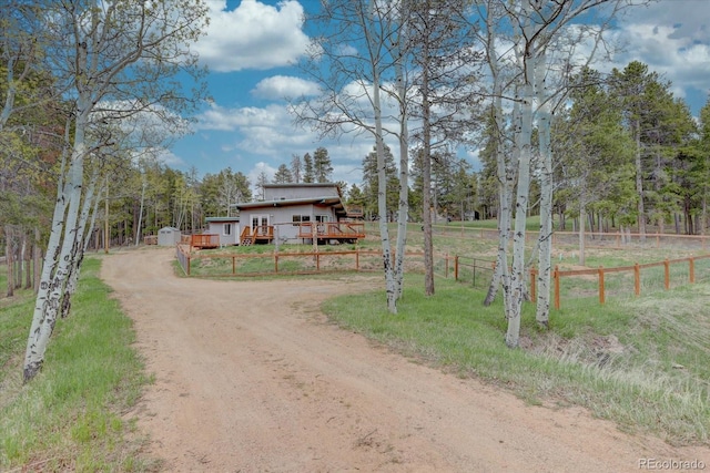 9288 Krashin Dr, Conifer, CO 80433 - view of front of house with driveway, a wooden deck, and fence