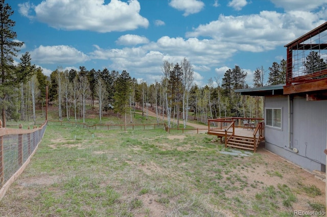 9288 Krashin Dr, Conifer, CO 80433 - view of yard with fence, a deck, and a wooded view