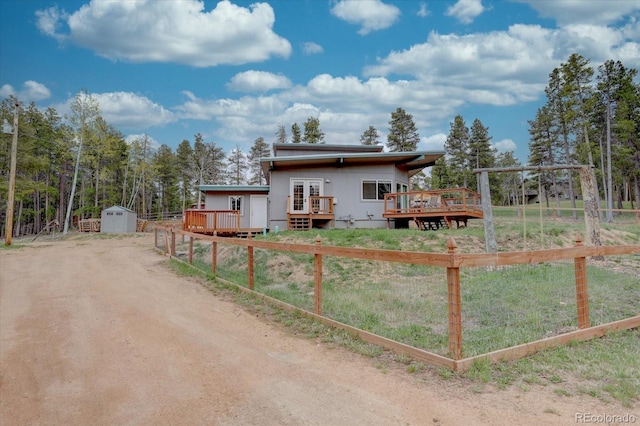 9288 Krashin Dr, Conifer, CO 80433 - view of front of home with a wooden deck, an outbuilding, fence, and a storage shed