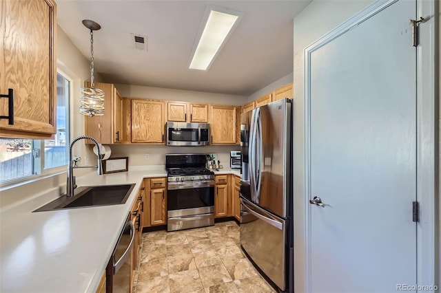 kitchen featuring sink, stainless steel appliances, and hanging light fixtures