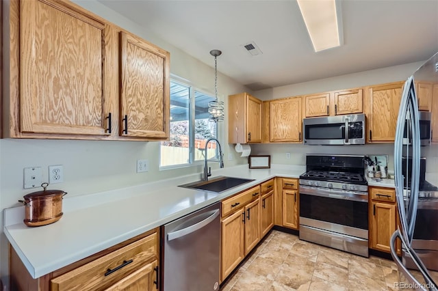 kitchen featuring pendant lighting, sink, and appliances with stainless steel finishes