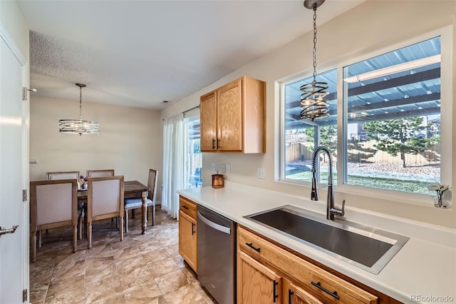 kitchen with stainless steel dishwasher, pendant lighting, and sink