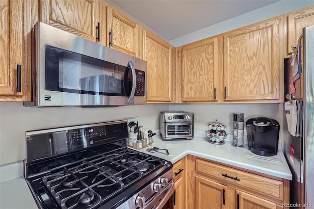 kitchen with light brown cabinets and black range with gas cooktop