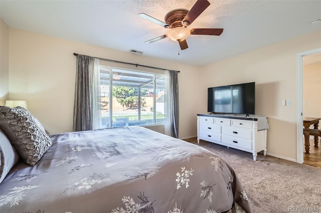 carpeted bedroom featuring ceiling fan, access to exterior, and a textured ceiling