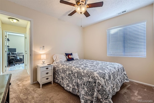 carpeted bedroom featuring a textured ceiling and ceiling fan