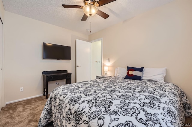 carpeted bedroom with ceiling fan and a textured ceiling