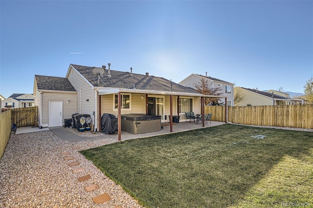 rear view of property with a yard, a patio, and a hot tub