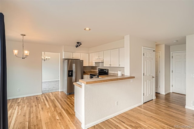 16645 W 2nd Ave, Golden, CO 80401 - kitchen with stainless steel appliances, under cabinet range hood, a chandelier, light wood finished floors, and a peninsula