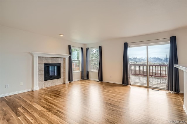 16645 W 2nd Ave, Golden, CO 80401 - unfurnished living room featuring a tiled fireplace and wood finished floors