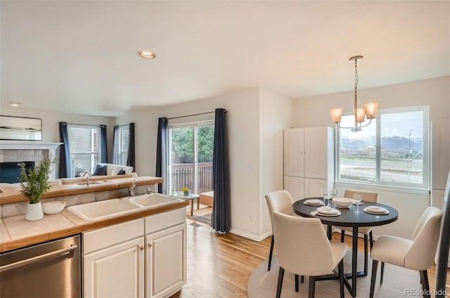 16645 W 2nd Ave, Golden, CO 80401 - kitchen with dishwasher, a chandelier, light wood-style floors, pendant lighting, and white cabinetry