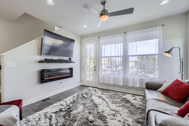 living room with ceiling fan, dark hardwood / wood-style flooring, and a wealth of natural light