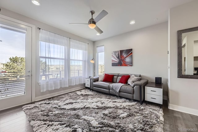 living room featuring dark wood-type flooring and ceiling fan