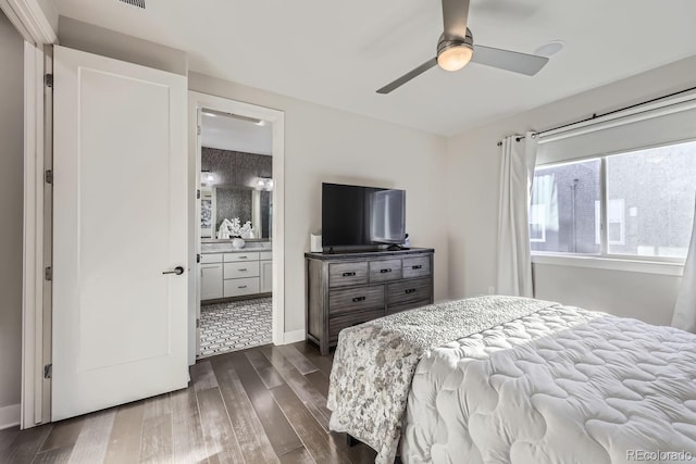 bedroom with dark wood-type flooring, ensuite bath, and ceiling fan