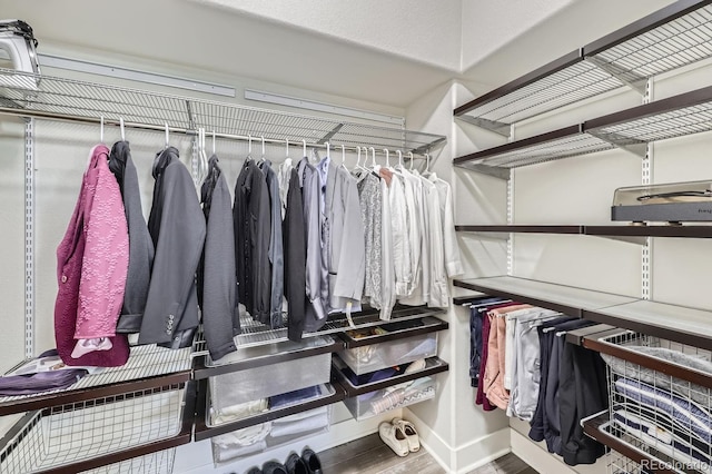 walk in closet with hardwood / wood-style flooring