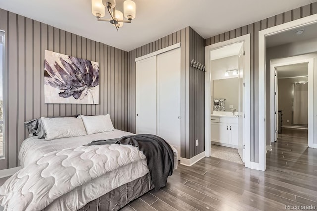 bedroom with a closet, dark wood finished floors, baseboards, and wallpapered walls