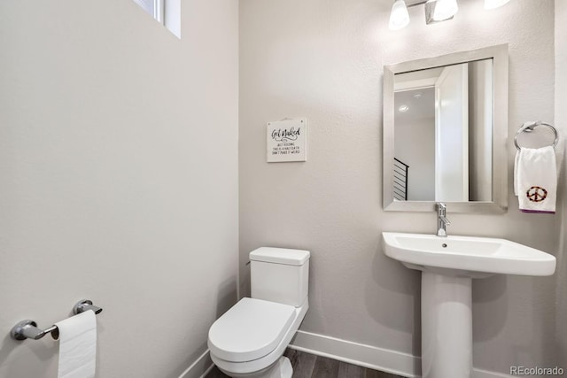 bathroom featuring wood-type flooring and toilet