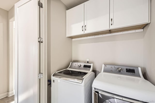 washroom with cabinets and washer and dryer