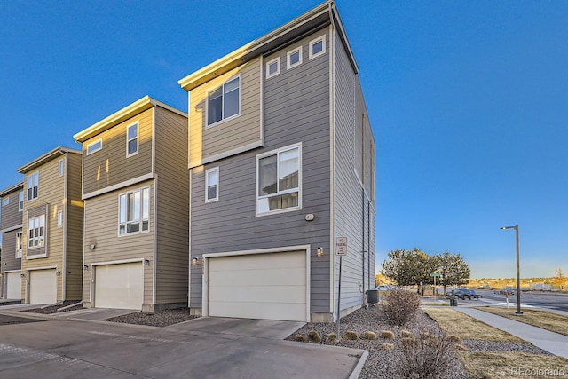 view of front of home with a garage and central AC