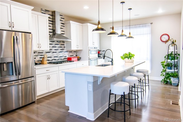 15878 E Broncos Pl, Englewood, CO 80112 - kitchen with appliances with stainless steel finishes, wall chimney range hood, tasteful backsplash, light countertops, and recessed lighting