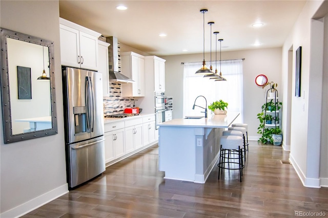 15878 E Broncos Pl, Englewood, CO 80112 - kitchen featuring stainless steel appliances, a sink, wall chimney range hood, an island with sink, and tasteful backsplash