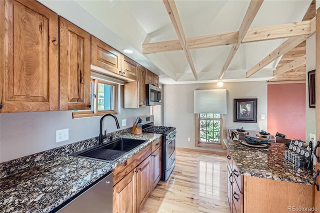 903 High Rd, Manitou Springs, CO 80829 - kitchen with appliances with stainless steel finishes, beam ceiling, healthy amount of natural light, dark stone countertops, and light wood-style flooring