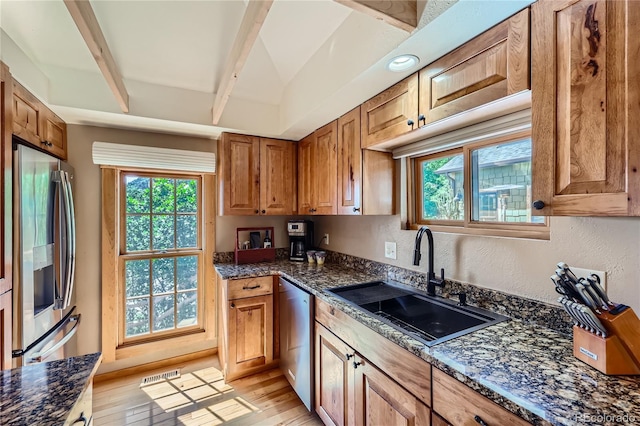 903 High Rd, Manitou Springs, CO 80829 - kitchen featuring appliances with stainless steel finishes, plenty of natural light, light wood-style floors, beamed ceiling, and dark stone counters