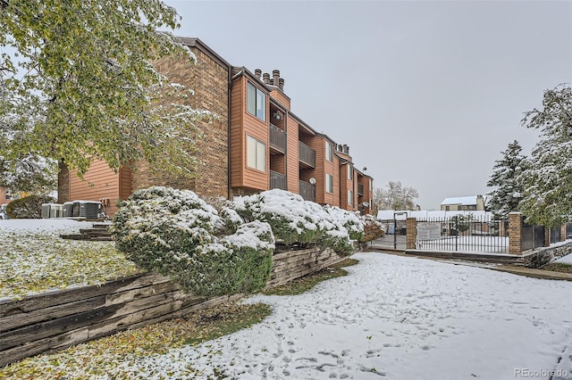 snow covered building featuring cooling unit