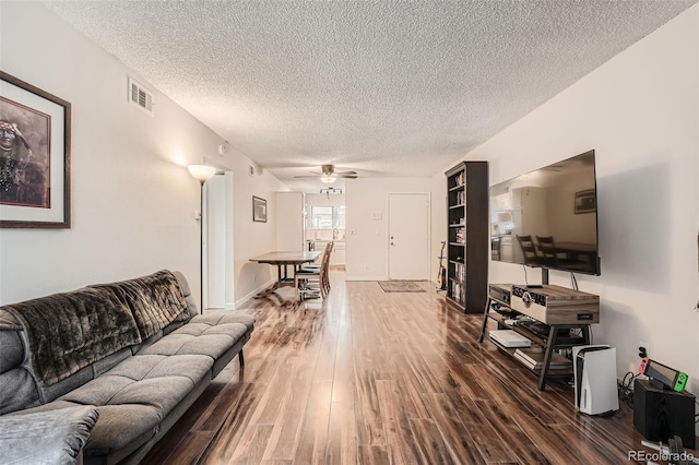 living room featuring a textured ceiling, dark hardwood / wood-style floors, and ceiling fan