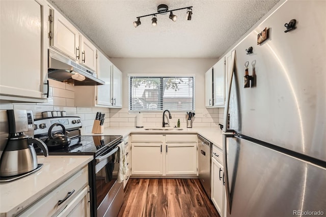 kitchen with white cabinets, appliances with stainless steel finishes, a textured ceiling, and sink