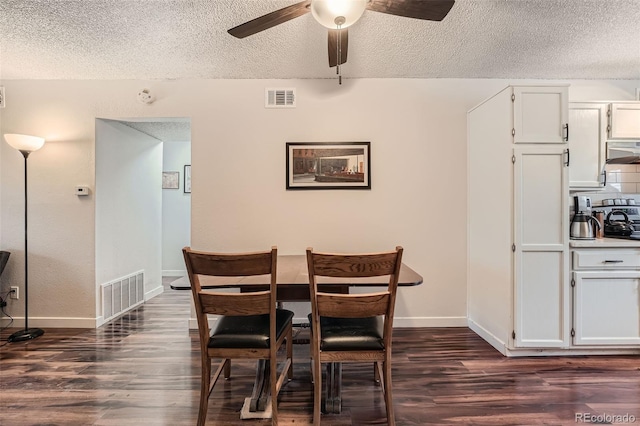 dining room featuring dark wood-type flooring, a textured ceiling, and ceiling fan