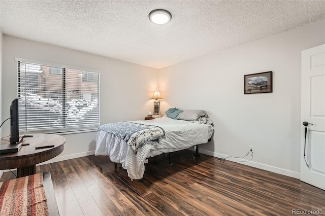 bedroom featuring a textured ceiling and dark hardwood / wood-style floors