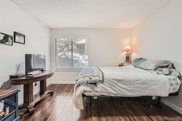 bedroom with a textured ceiling and hardwood / wood-style flooring