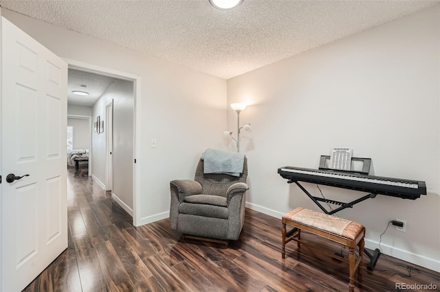 living area featuring dark hardwood / wood-style flooring and a textured ceiling