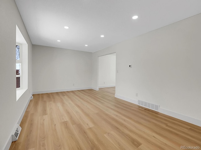 unfurnished room featuring light wood finished floors, baseboards, and visible vents