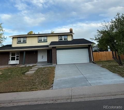 8694 E Eastman Ave, Denver, CO 80231 - traditional home with concrete driveway, a porch, an attached garage, a chimney, and brick siding