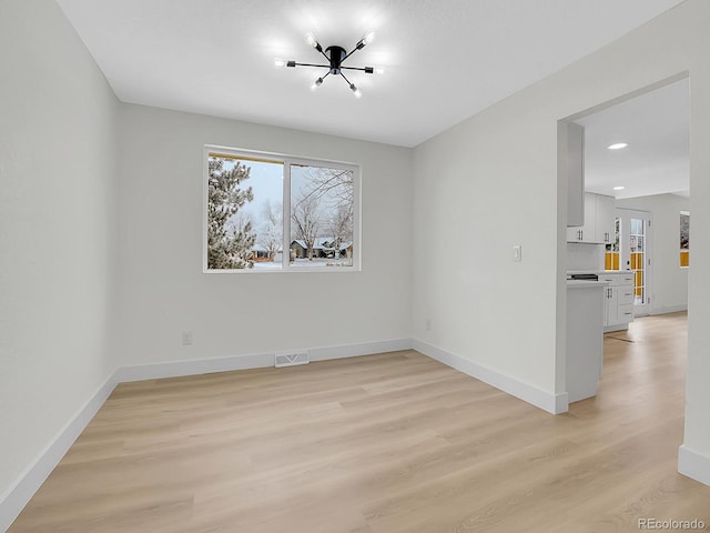 8694 E Eastman Ave, Denver, CO 80231 - empty room featuring a chandelier, plenty of natural light, light wood finished floors, baseboards, and recessed lighting