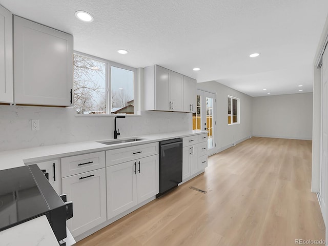 8694 E Eastman Ave, Denver, CO 80231 - kitchen with black dishwasher, a sink, backsplash, range, and light countertops