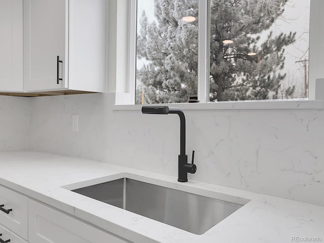 8694 E Eastman Ave, Denver, CO 80231 - kitchen with a sink, white cabinetry, and light stone counters