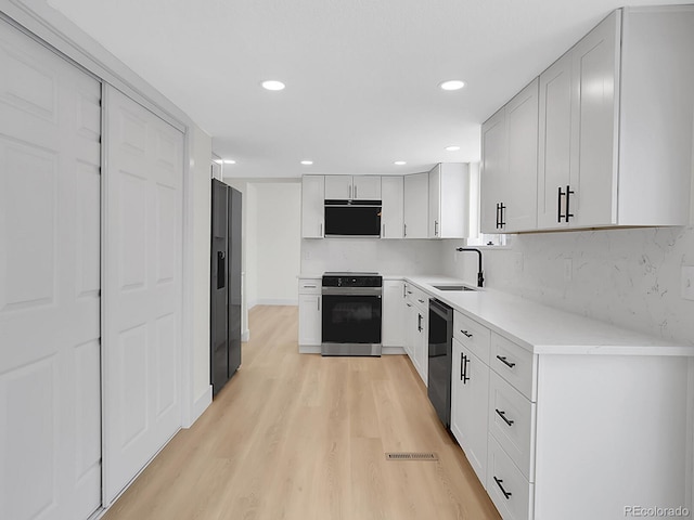 8694 E Eastman Ave, Denver, CO 80231 - kitchen with electric stove, a sink, dishwasher, light wood-style flooring, and decorative backsplash
